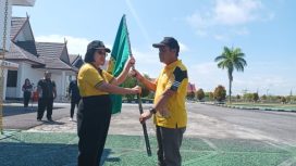 Diberangkatkan -  Wabup Gumas Efrensia LP Umbing menyerahkan bendera Kabupaten Gumas kepada Kepala Dinas Kebudayaan dan Pariwisata Hansli Gonak, saat pelepasan peserta kontingen FBIM tahun 2023, Jumat (19/05/2023). (FOTO: VRI)