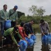 Anggota DPRD Gumas Untung Jaya Bangas (kemeja biru) menebarkan benih ikan papuyu 30 ribu ekor di Dam Sekata Kelurahan Tewah Kecamatan Tewah baru-baru ini.