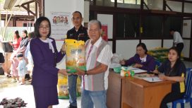 PENYERAHAN : Yang Mewakili Pemimpin Cabang (Pincab) Bank Kalteng Kurun Nanie sedang menyerahkan paket sembako untuk warga yang sedang menebus paket di UPK Sangkurun, Selasa (02/04/2024).