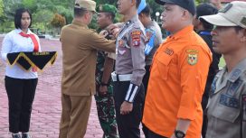 PEMASANGAN : Bupati Gunung Mas Jaya S Monong sedang memasang pin tanda operasi ketupat dimulai di depan halaman kantor Polres Setempat, Rabu (3/4/2024).
