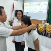 Kepala DPU Gunung Mas Baryen saat menyematkan kartu tanda perserta di aula Bapperida, Rabu (24/4/2024).