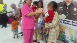 Ketua Bhayangkari Cabang Katingan Mika Putu. Saat memberikan bingkisan kepada ibu dan anak yang ikut Gebyar Posyandu Presisi