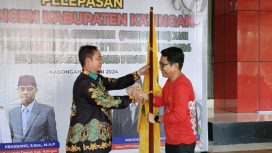 FOTO : Pj Bupati Katingan Saiful, saat menyerahkan bendera pataka kepada Ketua Panitia Mozard D Staing, sebagai tanda keberangkatan Kontingen Katingan mengikuti Pesparawi tingkat Kalteng. 