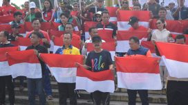 Pj Bupati Gumas Herson B Aden sedang memberikan bendera kepada camat dan tokoh masyarakat untuk dikibarkan dilaksanakan di Taman Kota Kurun, Jumat (26/7/2024).