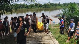 FOTO : Pihak Kepolisian dibantu warga saat evaluasi jenazah korban. 