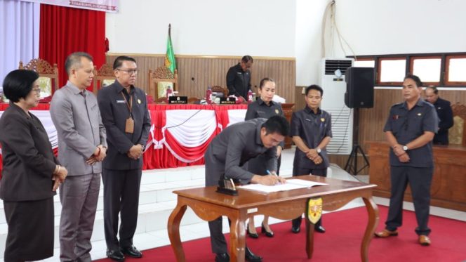 
					FOTO : Ketua DPRD Kabupaten Gumas Binartha, saat menandatangani pengesahan dan pengangkatan calon Bupati dan Wakil Bupati Gumas Terpilih. 