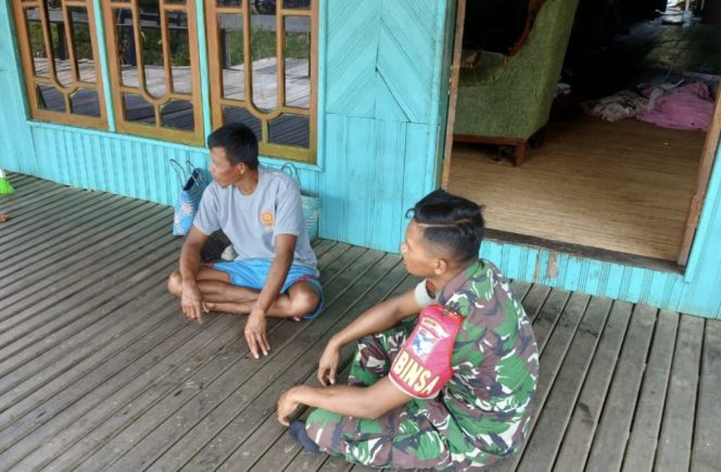
					FOTO : Babinsa Koramil 1019-02/Kamipang, Kopda Rois saat bersama warga.