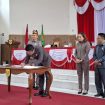 TANDA TANGAN : Ketua DPRD Kabupaten Gumas Binartha bersama Wakil Ketua I DPRD Nomi Aprilia dan Wakil Ketua II Espriadi, ketika menandatangani persetujuan bersama tiga buah raperda menjadi perda, di rapat paripurna ke-7 masa persidangan III tahun sidang 2025, Senin, 30 Juni 2025