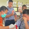 SUNTIK : Pegawai Puskesmas Tampang Tumbang Anjir saat melakukan pemeriksaan kesehatan gratis dengan menyuntik salah satu peserta didik SMPN 4 Kurun, pekan lalu.