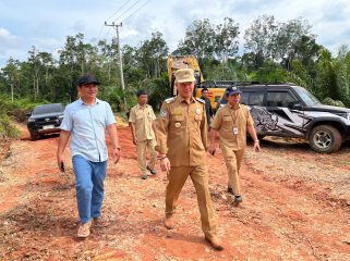 TINJAU : Anggota DPRD Kabupaten Gumas Herda (ujung kiri) bersama Bupati Jaya Samaya Monong, ketika meninjau pemeliharaan ruas jalan dari Desa Tumbang Kuayan menuju Tumbang Malahoi, pekan lalu.