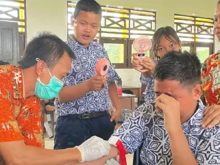 SUNTIK : Pegawai Puskesmas Tampang Tumbang Anjir saat melakukan pemeriksaan kesehatan gratis dengan menyuntik salah satu peserta didik SMPN 4 Kurun, pekan lalu.