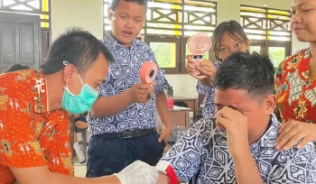 SUNTIK : Pegawai Puskesmas Tampang Tumbang Anjir saat melakukan pemeriksaan kesehatan gratis dengan menyuntik salah satu peserta didik SMPN 4 Kurun, pekan lalu.
