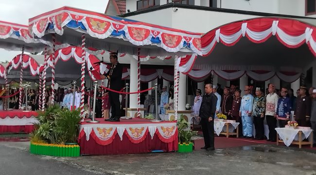 BACAKAN : Ketua DPRD Kabupaten Gumas Binartha ketika membacakan teks proklamasi, pada upacara penaikan bendera merah putih memperingati HUT ke-80 RI tahun 2025, di halaman kantor bupati, Minggu, 17 Agustus 2025