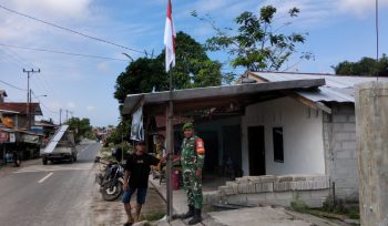 FOTO : Anggota TNI saat bersama warga memasang bendera merah putih.