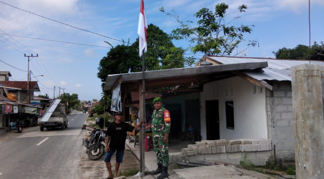 FOTO : Anggota TNI saat bersama warga memasang bendera merah putih.