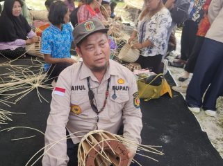 FOTO : Bupati Katingan Saiful, saat mencoba menganyam atau merajut bahan rotan menjadi produk kerajinan.