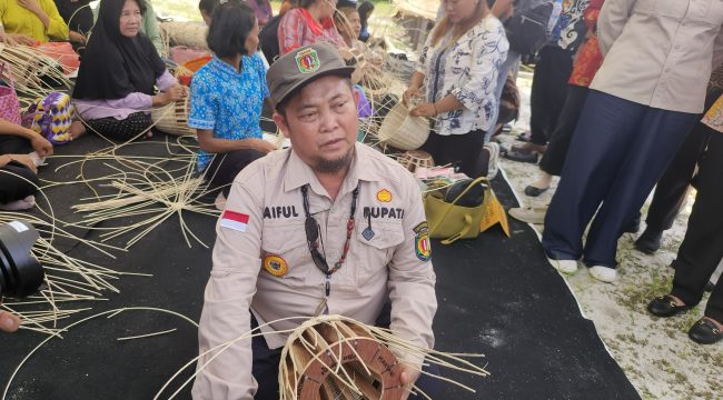 FOTO : Bupati Katingan Saiful, saat mencoba menganyam atau merajut bahan rotan menjadi produk kerajinan.