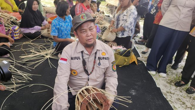 
					FOTO : Bupati Katingan Saiful, saat mencoba menganyam atau merajut bahan rotan menjadi produk kerajinan.