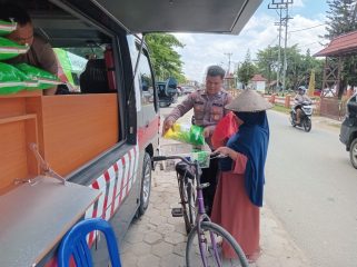 MENJUAL : Personel Satbinmas Polres Gumas saat menjual beras SPHP kepada warga, di Taman Kota Kuala Kurun, Sabtu, 8 November 2025.