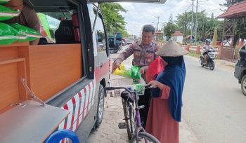 MENJUAL : Personel Satbinmas Polres Gumas saat menjual beras SPHP kepada warga, di Taman Kota Kuala Kurun, Sabtu, 8 November 2025.