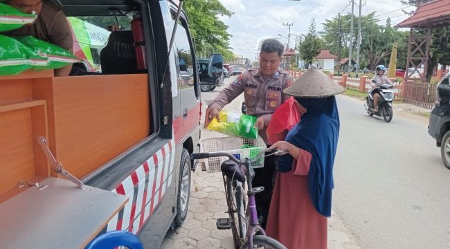 MENJUAL : Personel Satbinmas Polres Gumas saat menjual beras SPHP kepada warga, di Taman Kota Kuala Kurun, Sabtu, 8 November 2025.