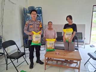 DISTRIBUSI : Personel Polsek Manuhing ketika mendistribusikan beras SPHP, Selasa, 11 November 2025