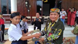 SERAHKAN : Pimpinan Bank Kalteng Cabang Kuala Kurun Empas S Umar didampingi Sekretaris Dinas Sosial Donie, ketika menyerahkan bantuan kepada pelajar sekolah rakyat, Kamis, 6 November 2025.