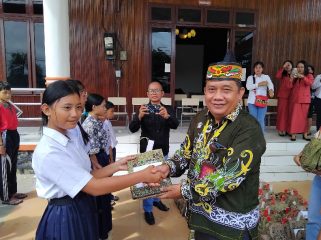 SERAHKAN : Pimpinan Bank Kalteng Cabang Kuala Kurun Empas S Umar didampingi Sekretaris Dinas Sosial Donie, ketika menyerahkan bantuan kepada pelajar sekolah rakyat, Kamis, 6 November 2025.