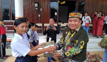 SERAHKAN : Pimpinan Bank Kalteng Cabang Kuala Kurun Empas S Umar didampingi Sekretaris Dinas Sosial Donie, ketika menyerahkan bantuan kepada pelajar sekolah rakyat, Kamis, 6 November 2025.