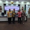 SERAHKAN : Pimpinan Bank Kalteng Cabang Kuala Kurun Empas S Umar saat menyerahkan alat rekam transaksi pajak ke Sekda Gumas, yang selanjutnya diserahkan ke para pelaku usaha, di ruang rapat lantai 1 kantor bupati setempat, Kamis, 4 Desember 2025.
