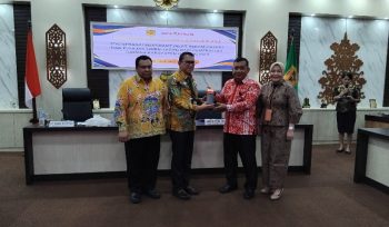 SERAHKAN : Pimpinan Bank Kalteng Cabang Kuala Kurun Empas S Umar saat menyerahkan alat rekam transaksi pajak ke Sekda Gumas, yang selanjutnya diserahkan ke para pelaku usaha, di ruang rapat lantai 1 kantor bupati setempat, Kamis, 4 Desember 2025.