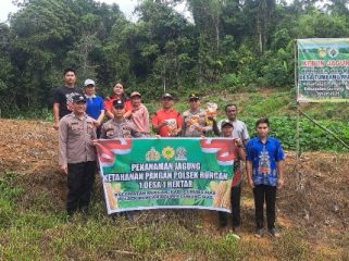FOTO BERSAMA : Kapolsek Rungan Ipda Muhamad Helmi Hakim, S.H, dan personel polsek, saat berfoto bersama dengan pemerintah desa dan pengurus BUMDes, usai penanaman jagung hibrida, di Kebun PKK Desa, Jumat, 3 April 2026.