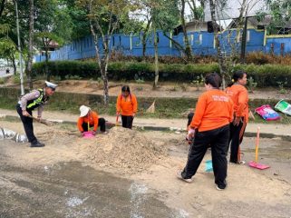 BERSIHKAN : Personel Satlantas Polres Gumas dan petugas kebersihan ketika membersihkan pasir yang ada di Bundaran Kota Kuala Kurun, Rabu, 22 April 2026.