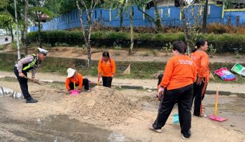 BERSIHKAN : Personel Satlantas Polres Gumas dan petugas kebersihan ketika membersihkan pasir yang ada di Bundaran Kota Kuala Kurun, Rabu, 22 April 2026.