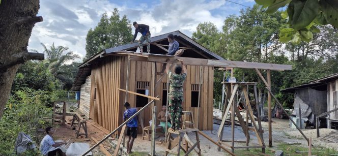 
					FOTO : Suasana pembangunan rumah dilakukan secara gotong royong dengan melibatkan personel TNI bersama masyarakat desa.