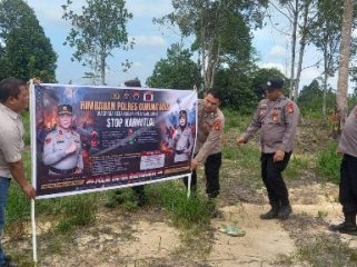 PASANG SPANDUK : Personel Polres Gumas yang tergabung dalam operasi bina karuna, melakukan pemasangan spanduk berisi imbauan larangan membakar hutan dan lahan, di Kecamatan Kurun, Kamis, 23 Juli 2026.