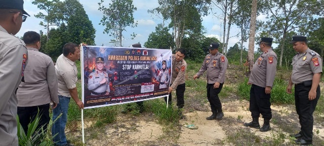 PASANG SPANDUK : Personel Polres Gumas yang tergabung dalam operasi bina karuna, melakukan pemasangan spanduk berisi imbauan larangan membakar hutan dan lahan, di Kecamatan Kurun, Kamis, 23 Juli 2026.