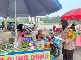 BAGIKAN MASKER : Kapolres Gumas AKBP Arum Sari Puspita Dewi, S.H, S.I.K, M.A, membagikan masker kepada pengendara yang melintas dan para pedagang di Taman Kota Kuala Kurun, Kamis, 13 Agustus 2026.
