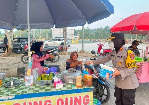 BAGIKAN MASKER : Kapolres Gumas AKBP Arum Sari Puspita Dewi, S.H, S.I.K, M.A, membagikan masker kepada pengendara yang melintas dan para pedagang di Taman Kota Kuala Kurun, Kamis, 13 Agustus 2026.
