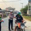BAGIKAN : Kasat Lantas Polres Gumas Iptu Eko Erry Setiawan, S.H, M.H didampingi personel satlantas, saat membagikan masker kepada pengendara roda dua dan empat yang melintas, di Pos Lantas Taman Kota Kuala Kurun, Rabu, 26 Agustus 2026.