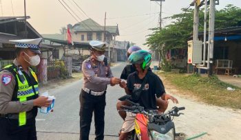 BAGIKAN : Kasat Lantas Polres Gumas Iptu Eko Erry Setiawan, S.H, M.H didampingi personel satlantas, saat membagikan masker kepada pengendara roda dua dan empat yang melintas, di Pos Lantas Taman Kota Kuala Kurun, Rabu, 26 Agustus 2026.