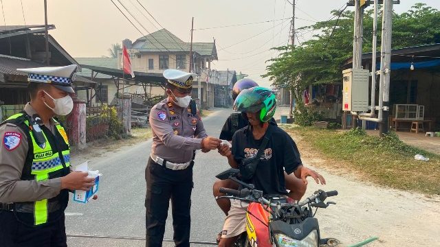 BAGIKAN : Kasat Lantas Polres Gumas Iptu Eko Erry Setiawan, S.H, M.H didampingi personel satlantas, saat membagikan masker kepada pengendara roda dua dan empat yang melintas, di Pos Lantas Taman Kota Kuala Kurun, Rabu, 26 Agustus 2026.