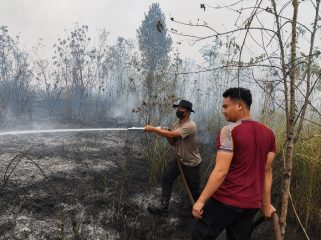 PADAMKAN : Personel Polres Gumas saat berupaya memadamkan api di pinggir Jalan Lintas Kuala Kurun-Linau, Kecamatan Kurun, Rabu, 26 Agustus 2026