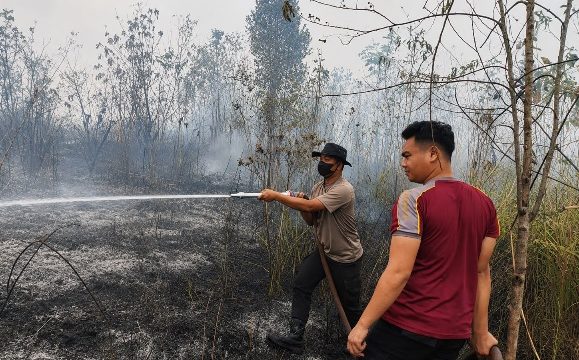PADAMKAN : Personel Polres Gumas saat berupaya memadamkan api di pinggir Jalan Lintas Kuala Kurun-Linau, Kecamatan Kurun, Rabu, 26 Agustus 2026