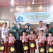 FOTO : Ketua TP PKK Kabupaten Katingan saat menyerahkan bantuan peralatan sekolah di Kecamatan Tewang Sangalang Garing.