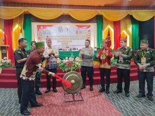 Staf Ahli Bupati dr Suria Siri Saat Memukul Gong Tanda Dibukanya Kegiatan Rapat Kerja DAD dan Peningkatan Kapasitas Damang, Sekdam, Mantir Kecamatan, Mantir adat Kelurahan / Desa se Kabupaten Murung Raya Tahun 2026 di Aula DAD Mura Jalan Tjilik Riwut Kota Puruk Cahu
