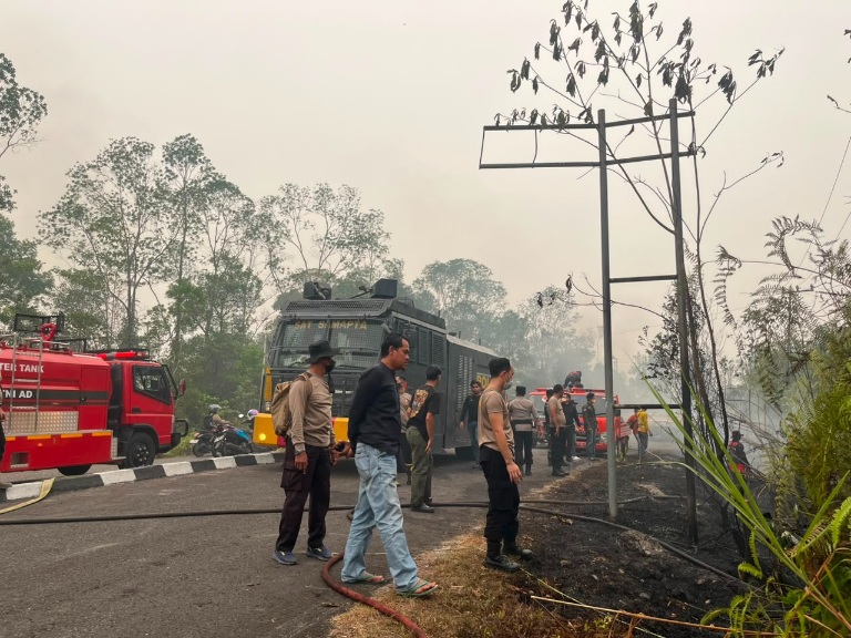 PADAMKAN : Piket Pamapta dan Tim Siaga Bencana Karhutla Polres Gumas saat memadamkan api di pinggir Jalan KS Tubun, Selasa, 15 September 2026.